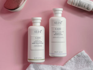 a bottle of keune care and a bottle of shampoo on a pink surface