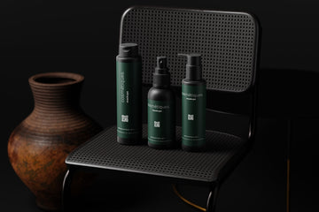 a black chair with three green bottles and a vase